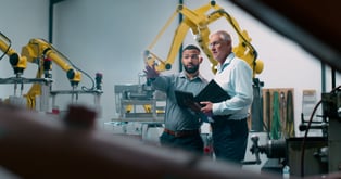 Two men discussing business in a manufacturing plant